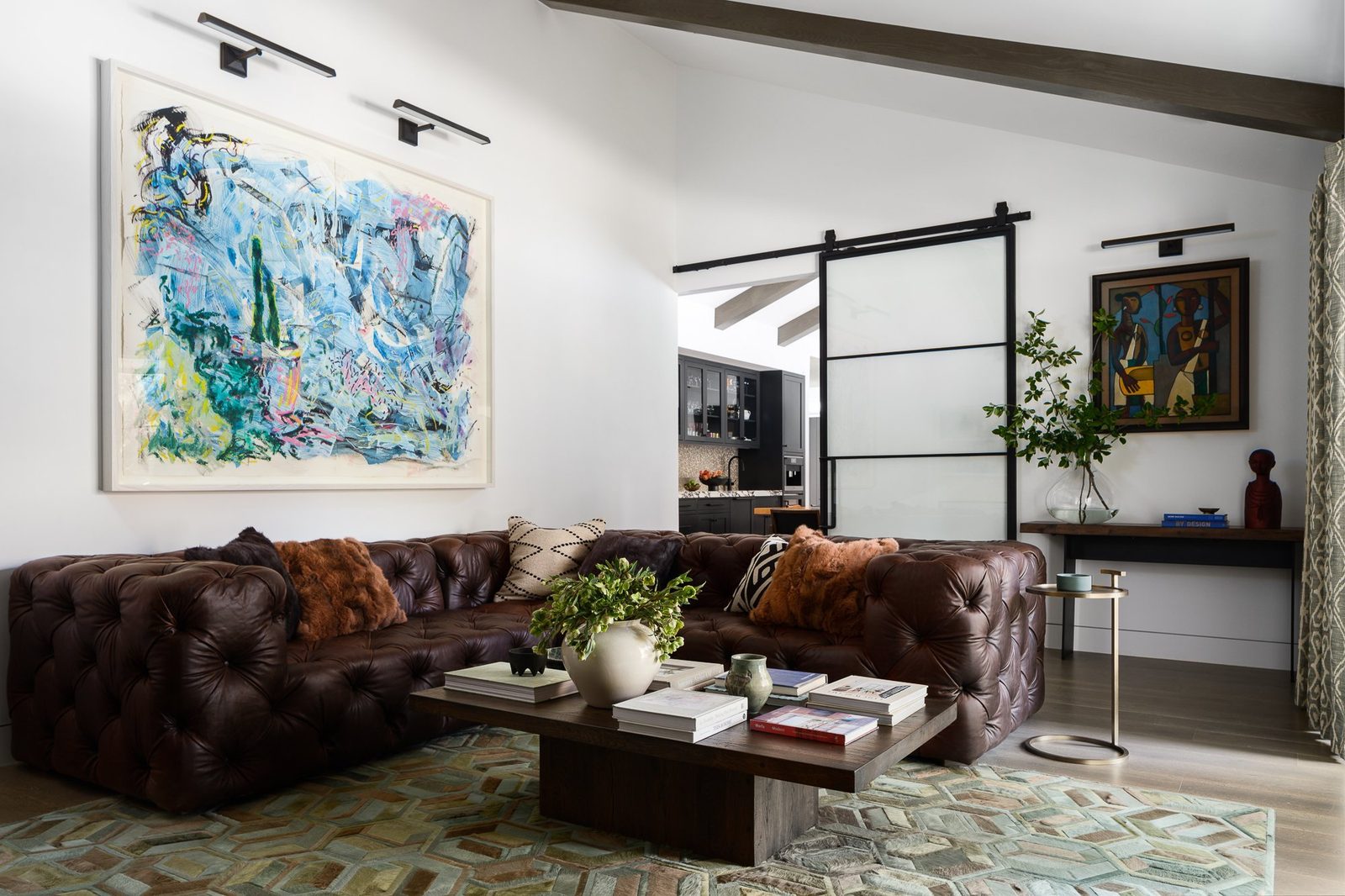 Great room in Atherton by Nash Design Group with a vaulted beamed ceiling, charcoal sectional and black steel windows